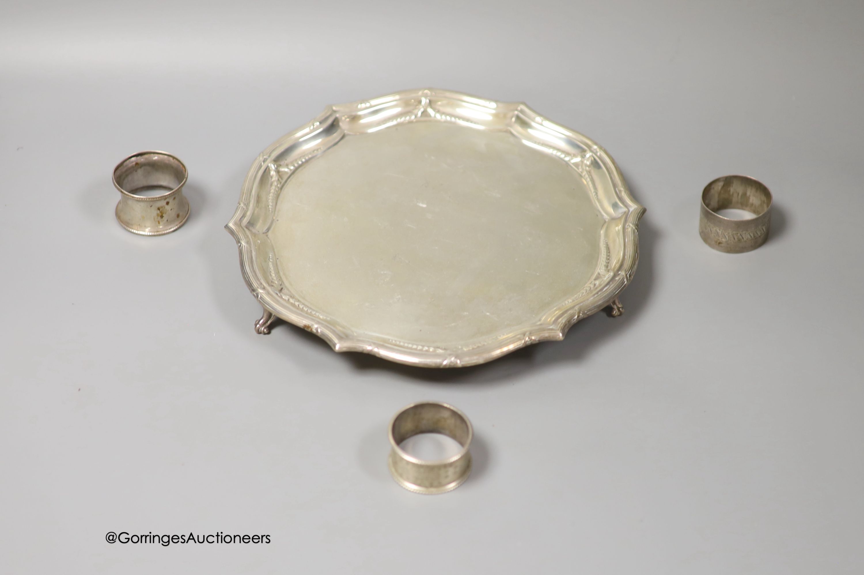 An Edwardian silver shaped circular salver, Goldsmiths & Silversmiths Co Ltd, London, 1902, 25cm and three silver napkin rings